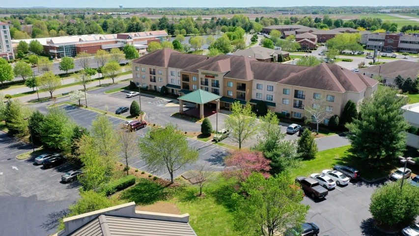 a very large parking lot with cars and some trees in it