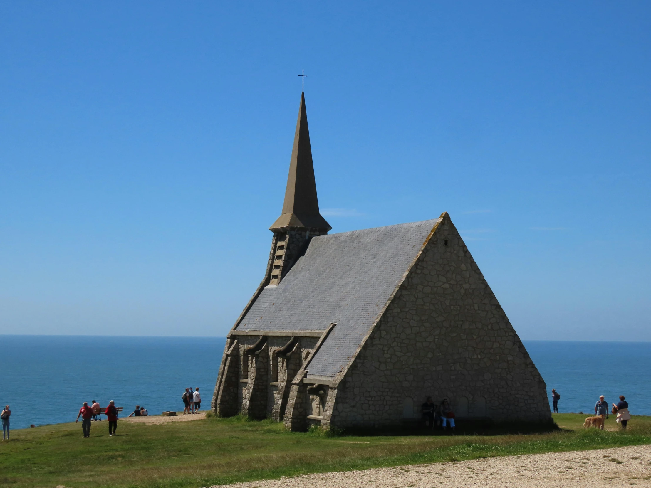 the people stand on the hillside near the small church