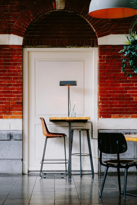 two chairs, a table and a lamp on an archway