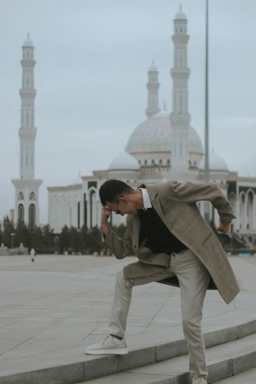 the man in a gray suit is doing a trick on stairs