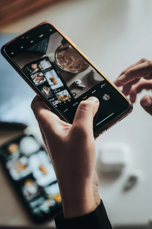 person using their cell phone at a table