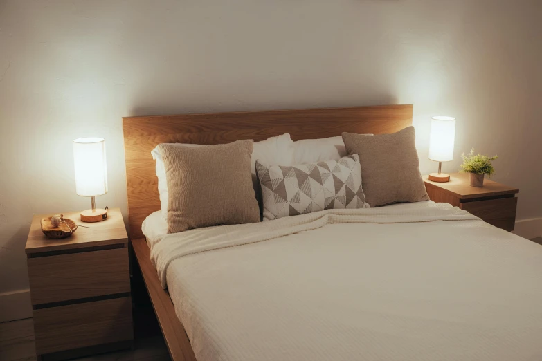 a bed with a light on and three pillows on top