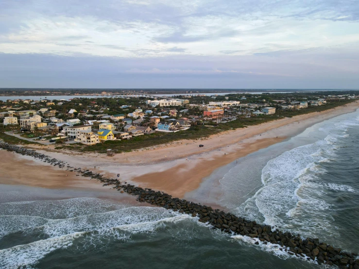 a beach with houses on it, and ocean waves