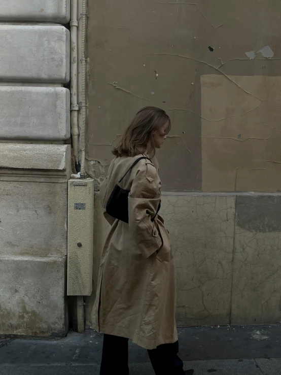 a woman walking past a very tall building