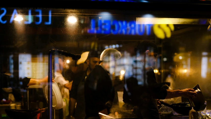 the reflection of two men are in the window of a restaurant