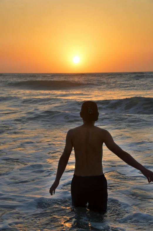 a man in the water during the sunset