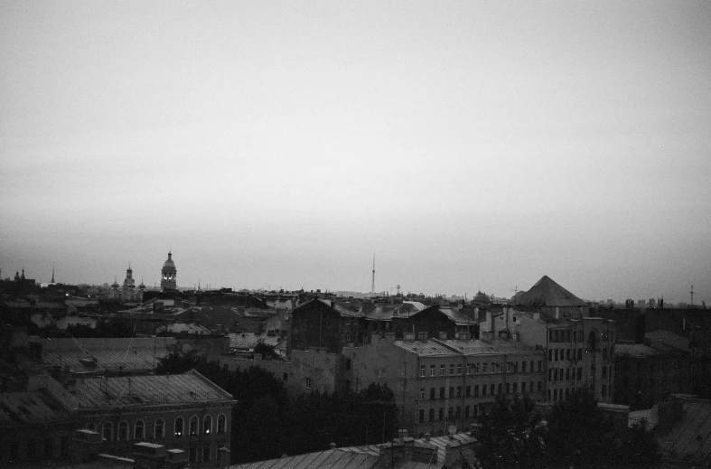 an old cityscape with a spire in the background