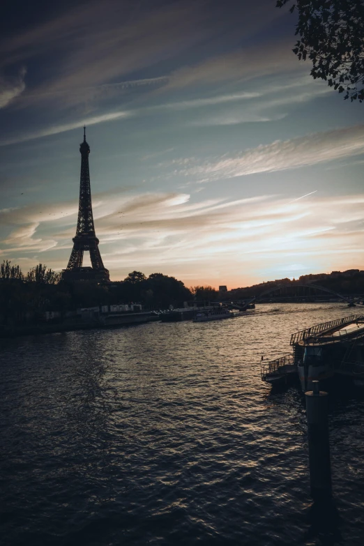 the eiffel tower towering over the city is at dusk