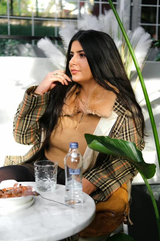 a woman is sitting down in a chair talking on the phone