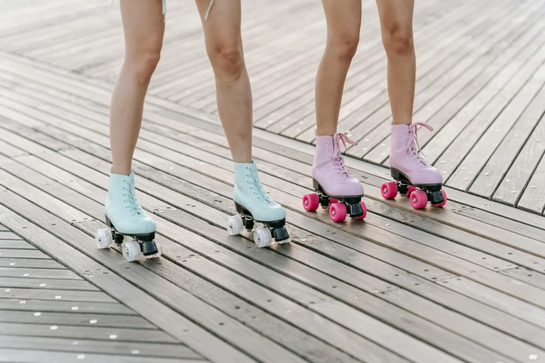 a couple of girls are riding skates on a dock