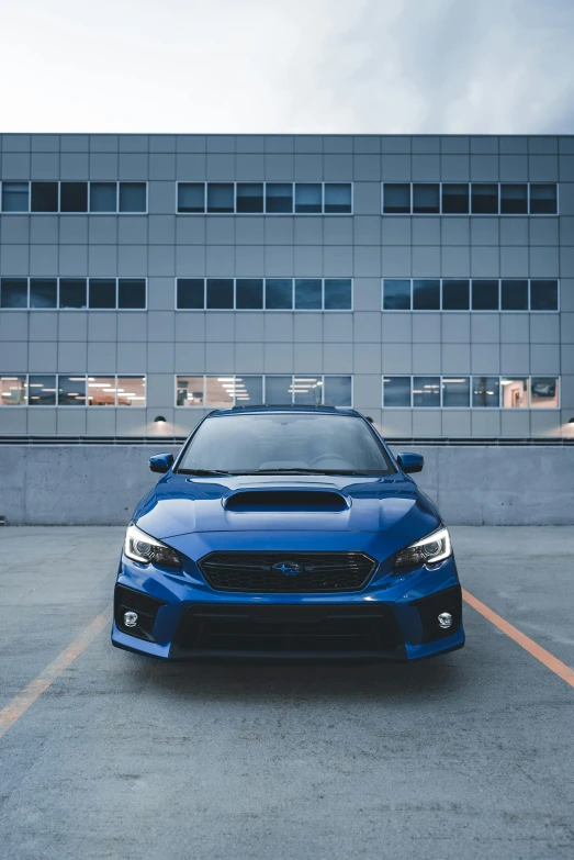 a blue subaru wrx sports is parked in the parking lot
