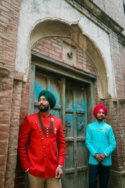 an indian man and woman standing outside of a large doorway