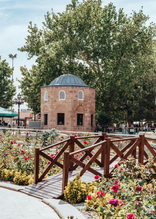 a wooden bench sitting next to a park covered with roses