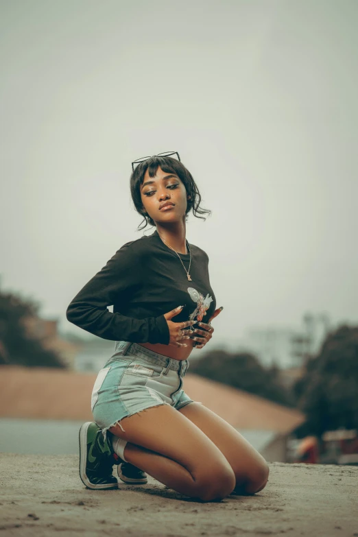 a black woman sitting down with her leg up and cellphone