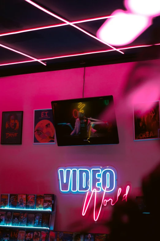 the neon sign for video world hangs from the ceiling