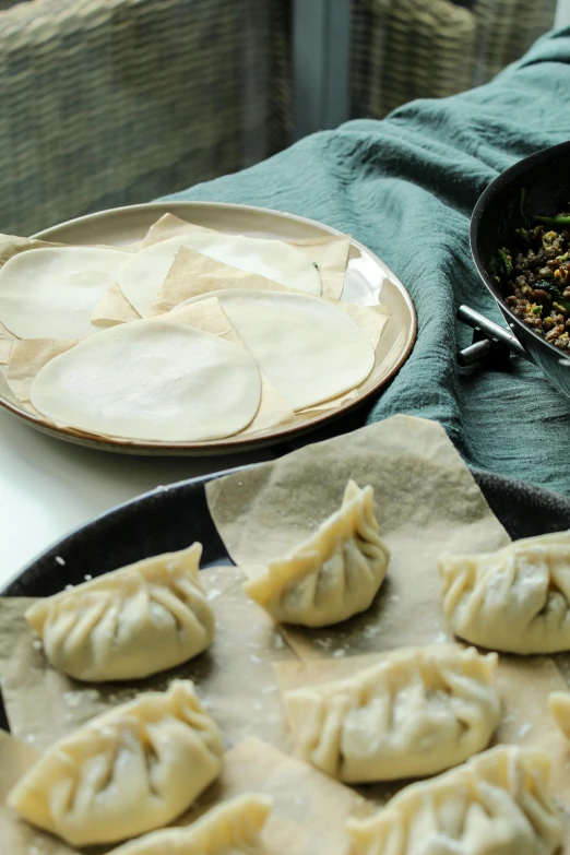 some dumplings are on some trays with sauce and seasoning