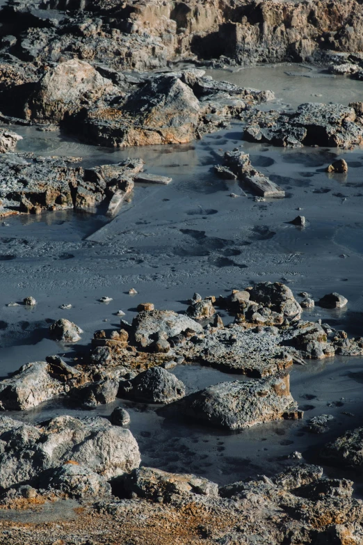 a group of rocks covered with water in the sun