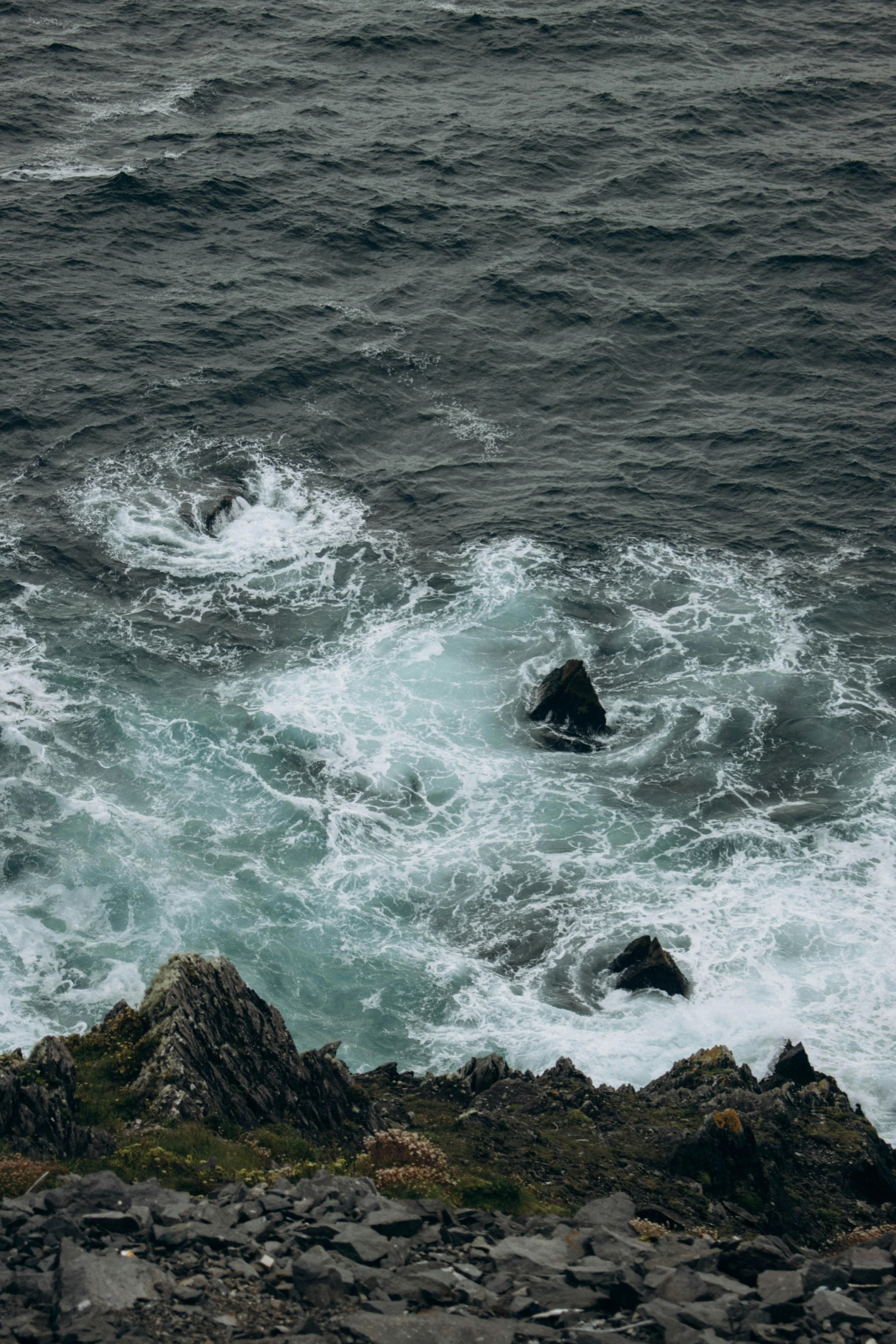 rough ocean with waves and rocks in foreground