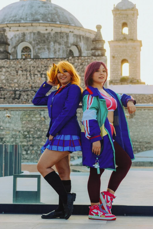 two young women standing next to each other in front of a building