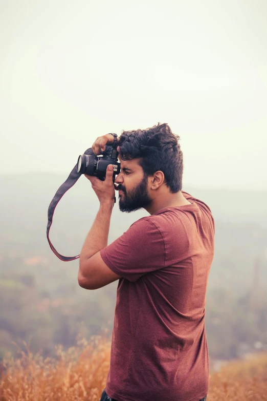 a man in a field taking a po of himself with his camera