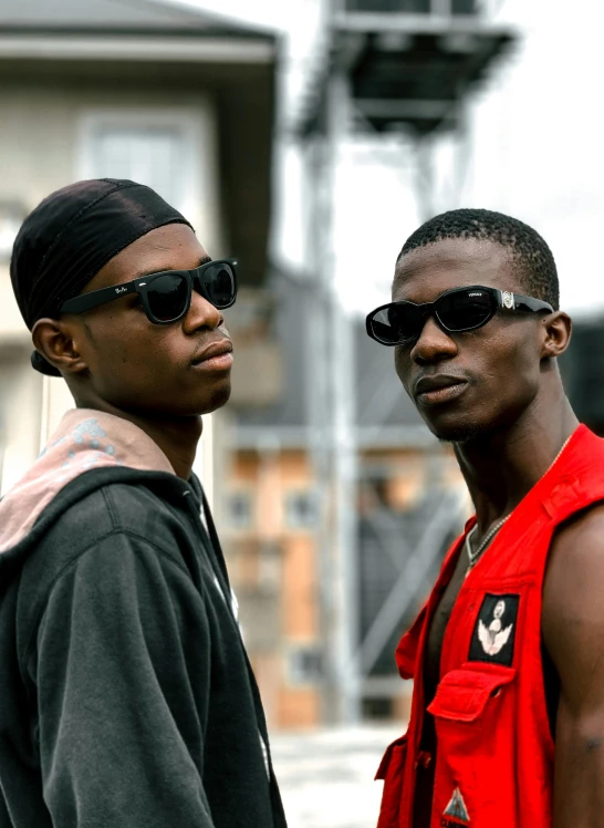two men wearing sunglasses are standing together