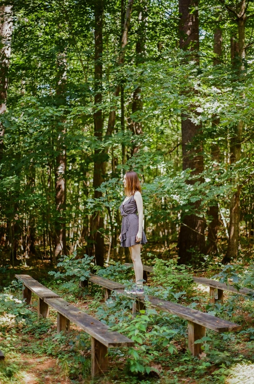 a woman walking over wooden crosses in the woods