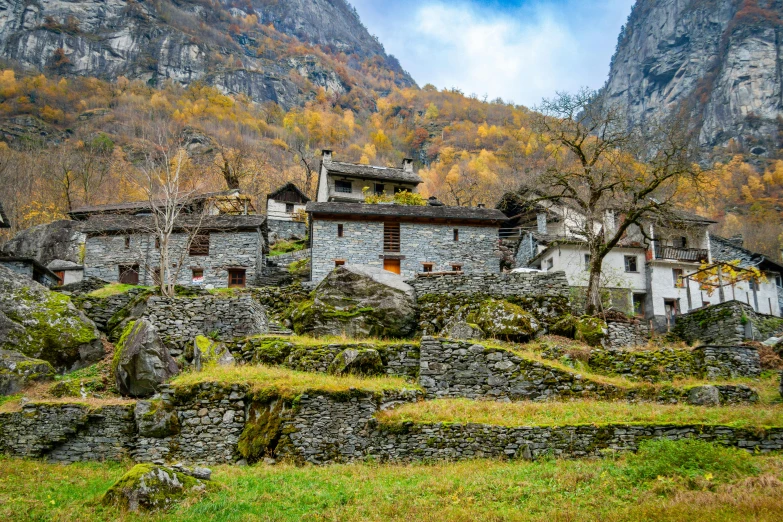 an old house in the mountains with trees on either side