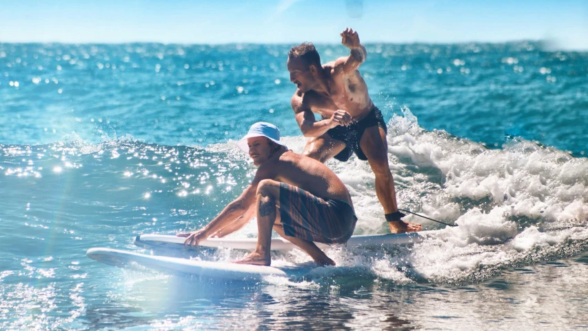 two people are riding on their surfboards at the beach