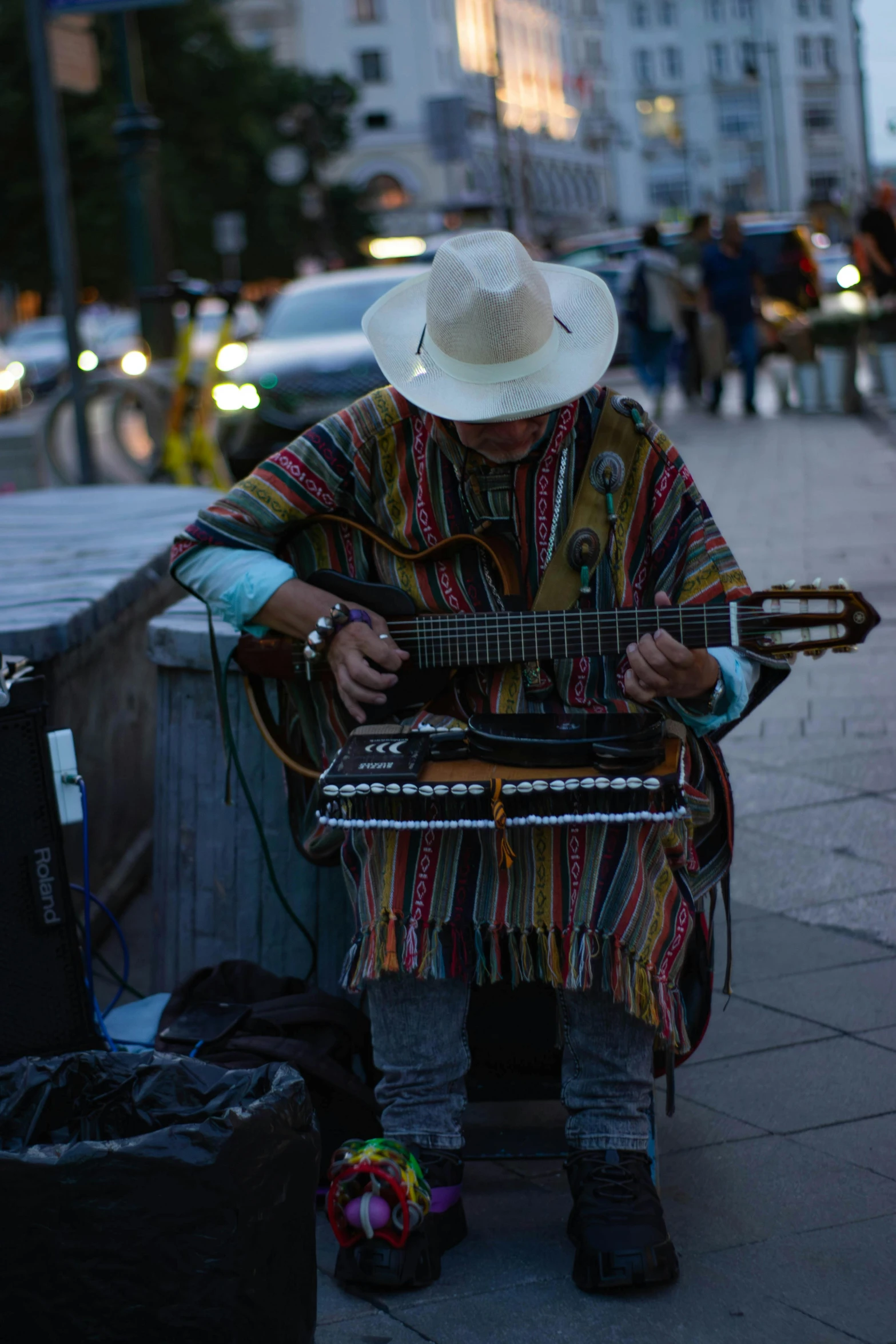 a person is sitting outside playing an instrument