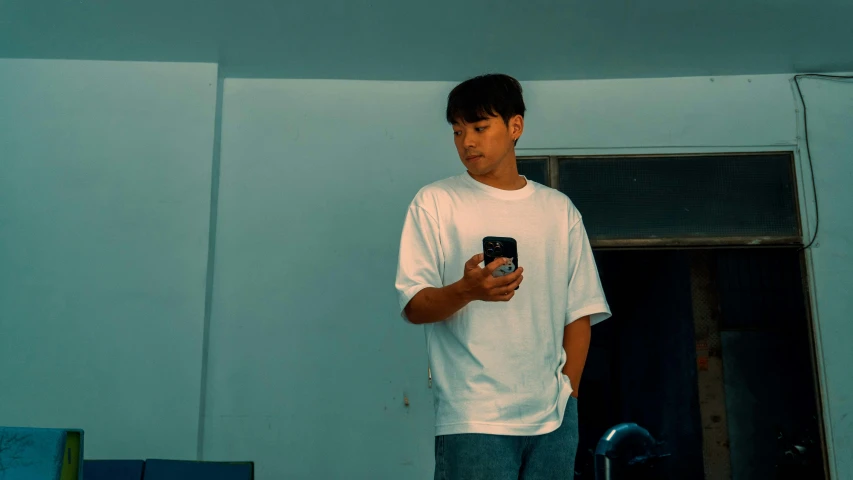 a man standing in a room holding a cellphone