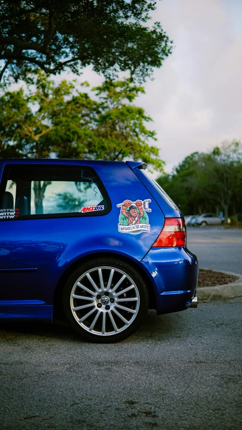 blue vw golf wm car with stickers on its hood