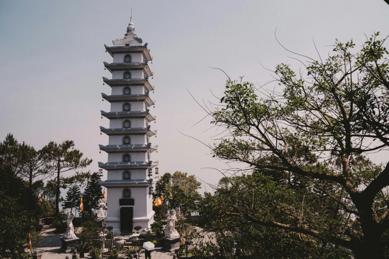 a white tower that is near some trees