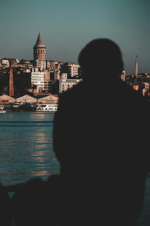 silhouette of man sitting with skyline in the background