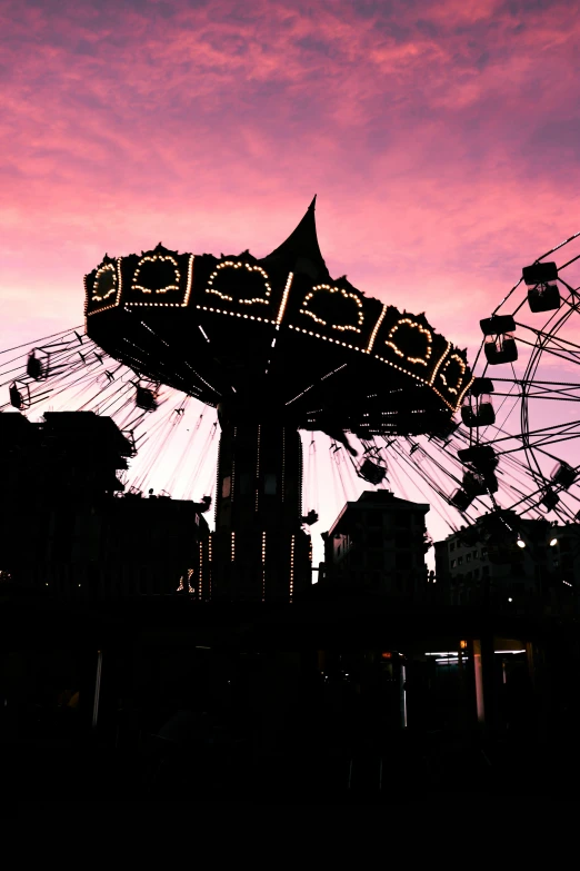 silhouette of an amut park rides and ferris wheel