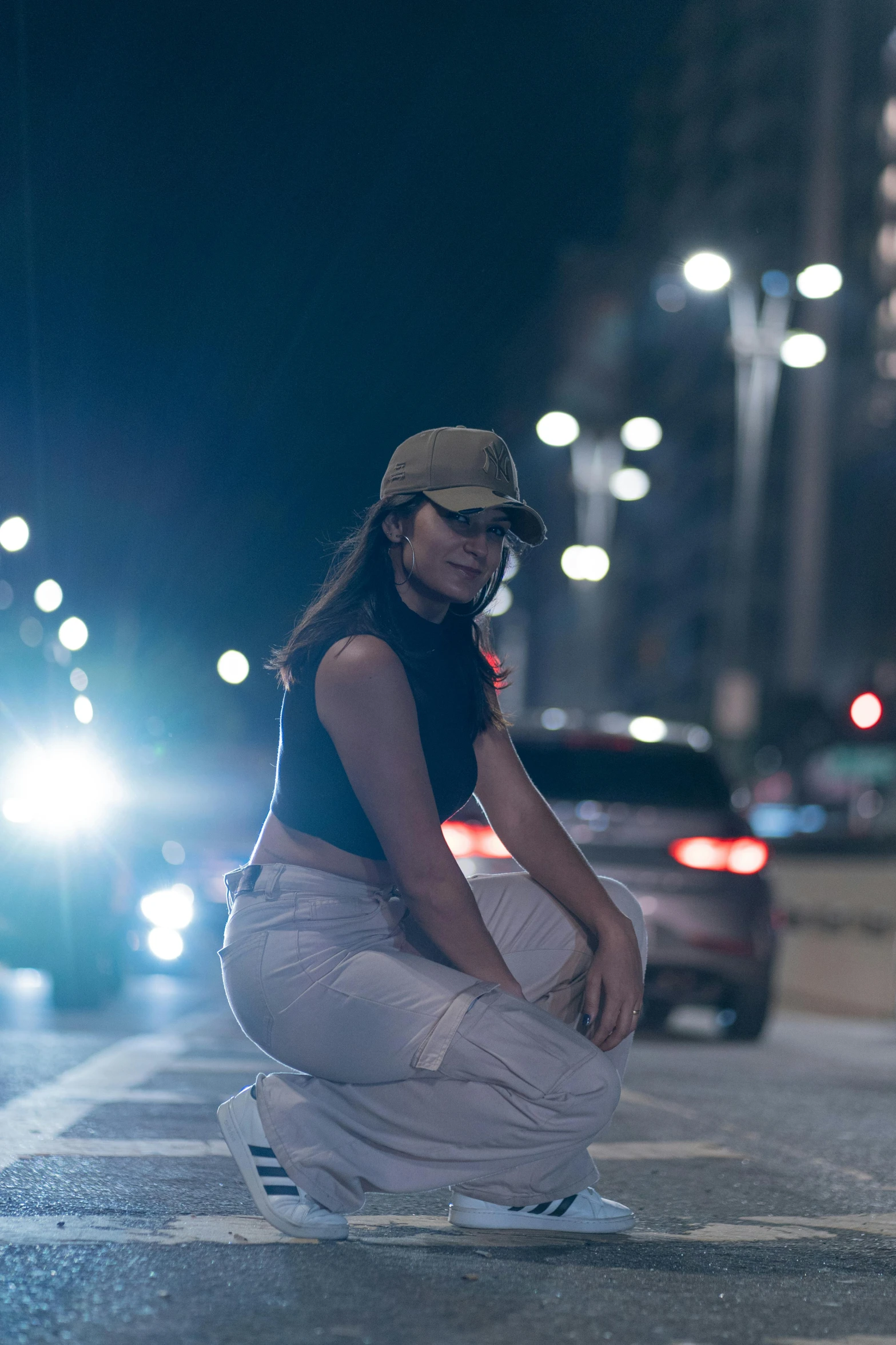 a woman crouched down on the curb near her car