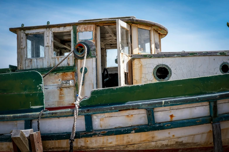 a dilapidated boat is seen against a blue sky