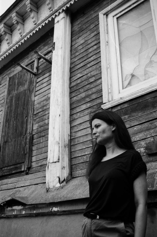 a woman standing in front of a wooden house