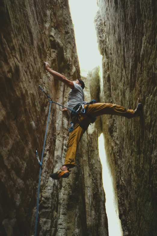 a man climbing up some rock with a rope