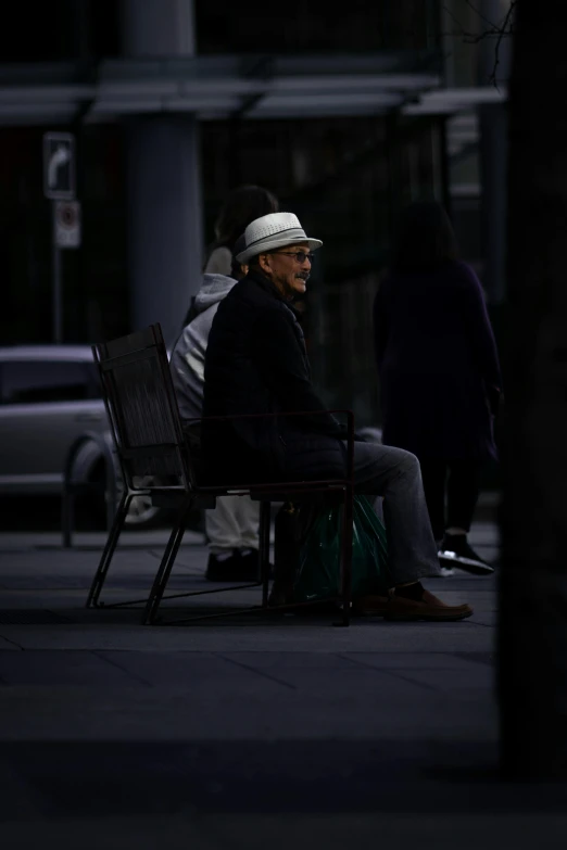 a man sitting on top of a chair next to a pole