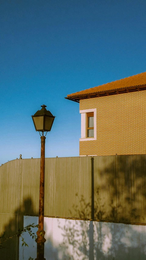 a street light and brick building near a fence