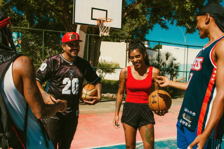 three people standing on a court with basketballs in hand