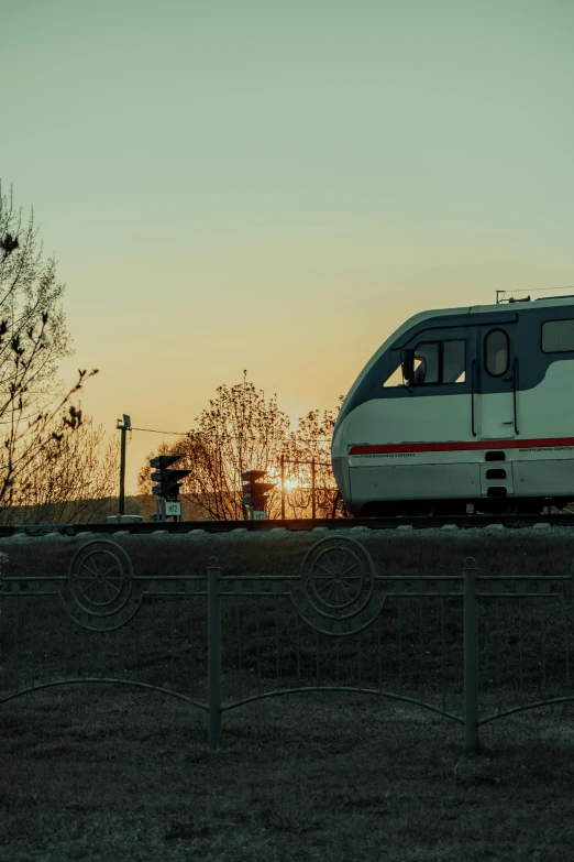 a train on the tracks near a fence