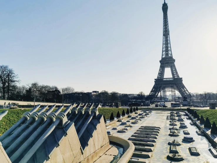 a long view of a fountain next to the eiffel tower