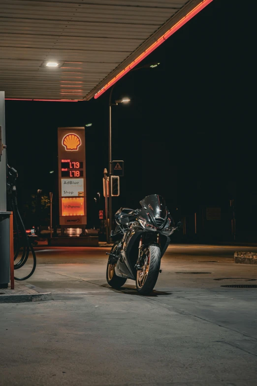 motorcycle at gas station parked next to no parking sign