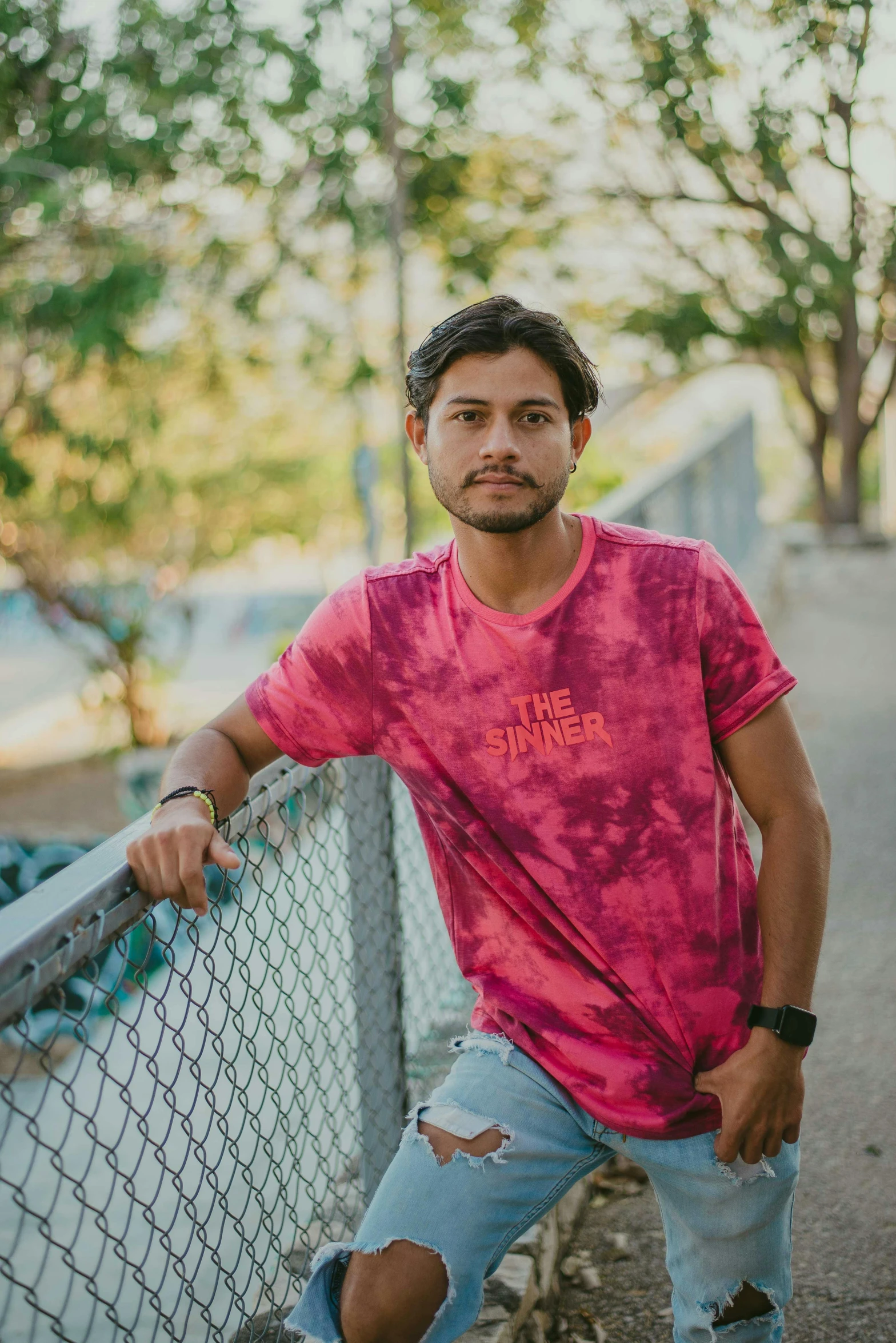 a man is leaning on a fence in front of the fence