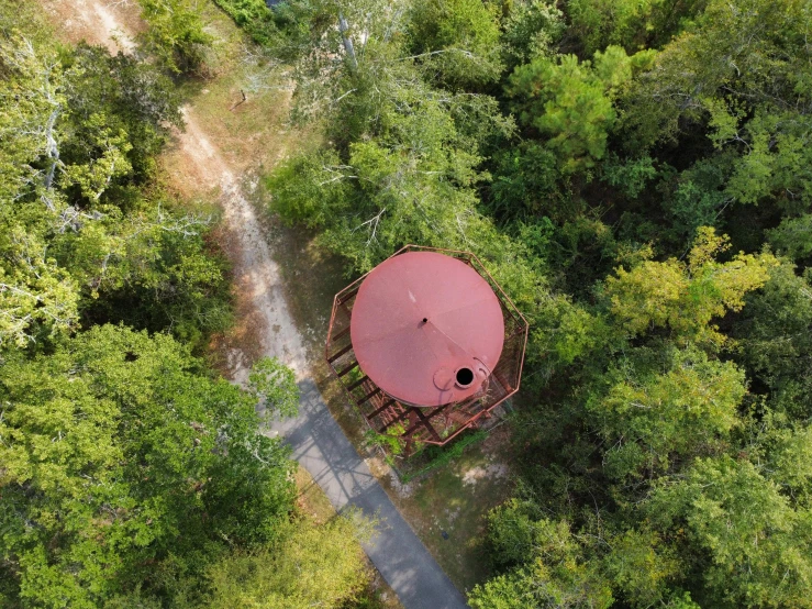 a brown wooden structure in the middle of a forest