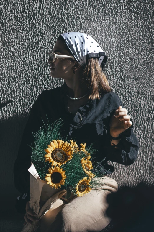 a woman holding a vase with sunflowers on it