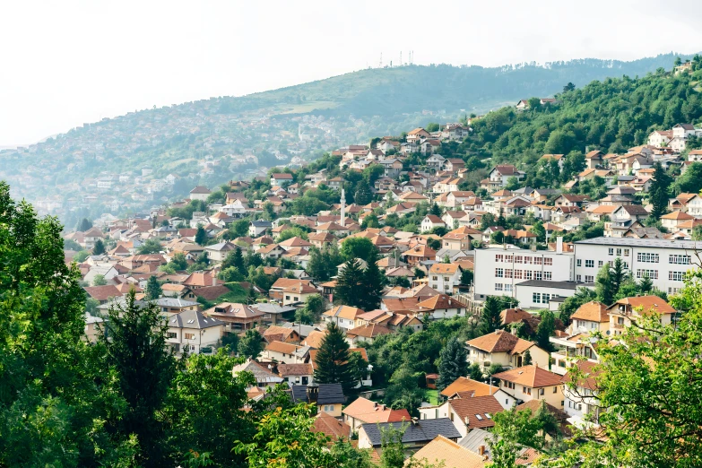 a village nestled above trees in a small mountain area