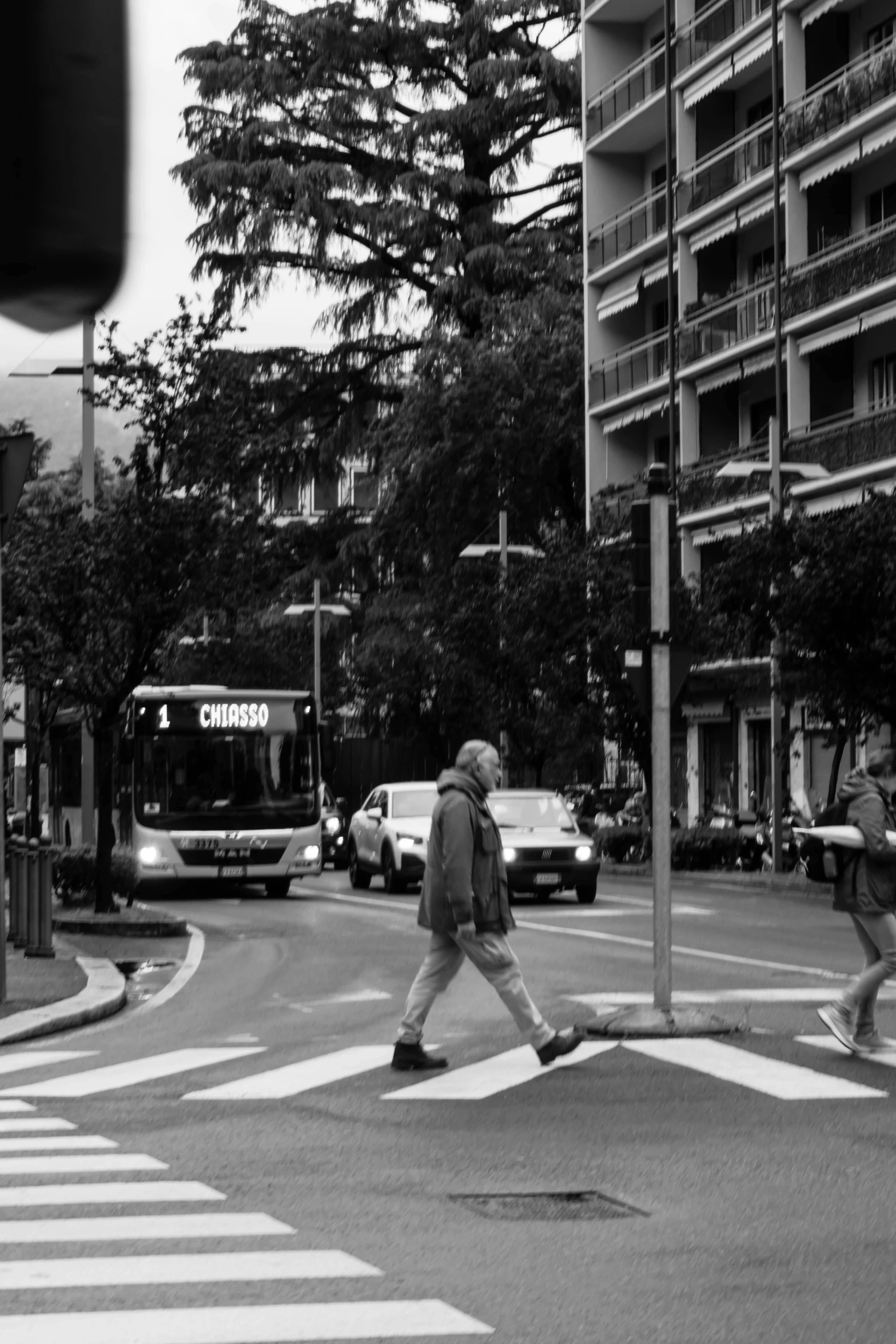 people are crossing the street in an intersection in black and white