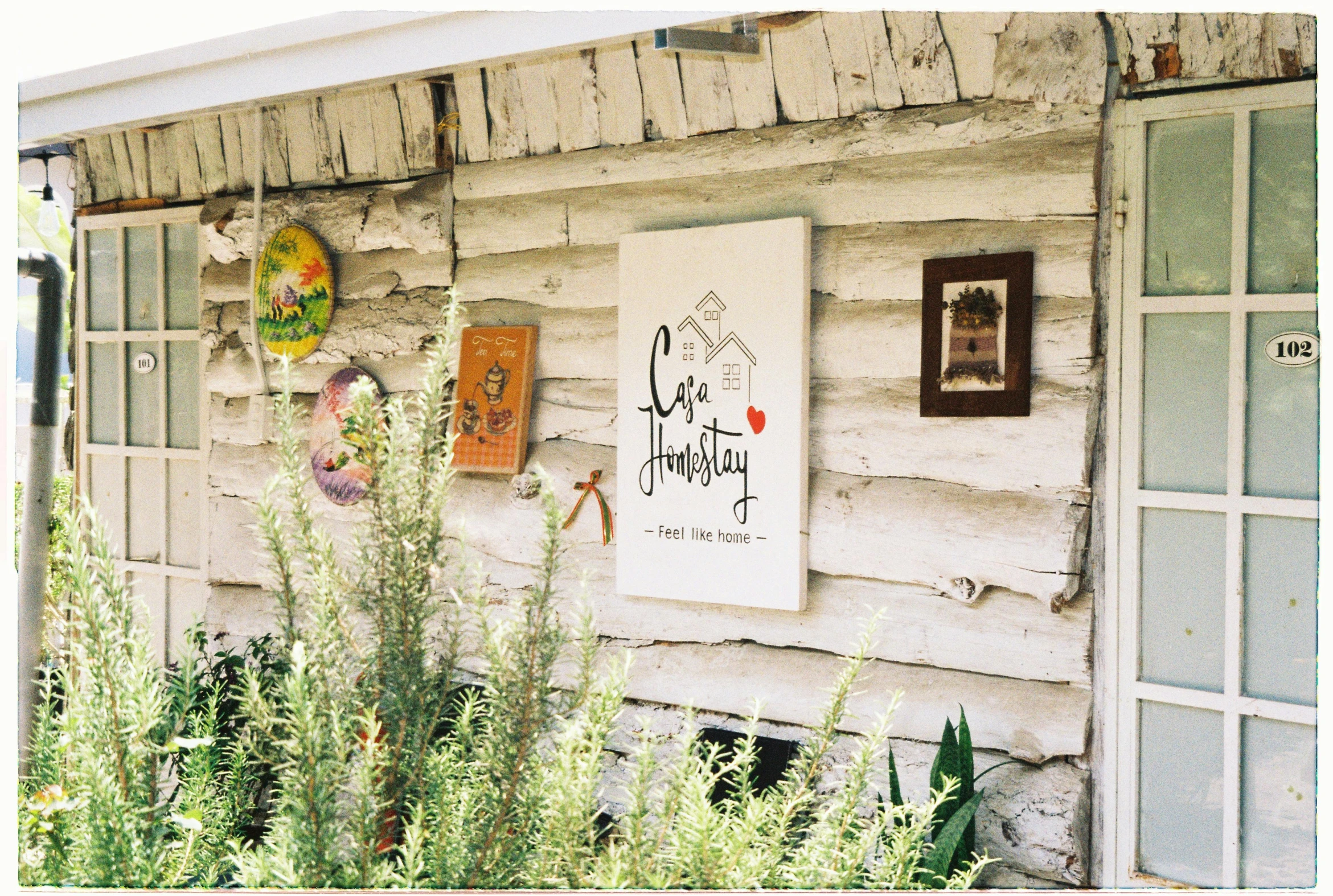 a weathered wooden building with a large bunch of pictures and posters